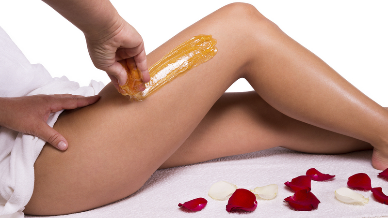 Wax treatment Sugaring: epilation with liquate sugar at legs.b