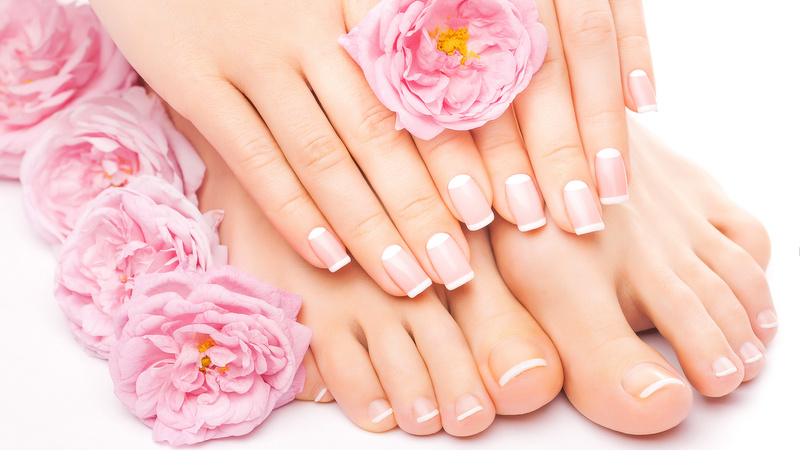 Relaxing pedicure and manicure with a pink rose flower french pedicure and manicure with a pink rose flower isolated on the white